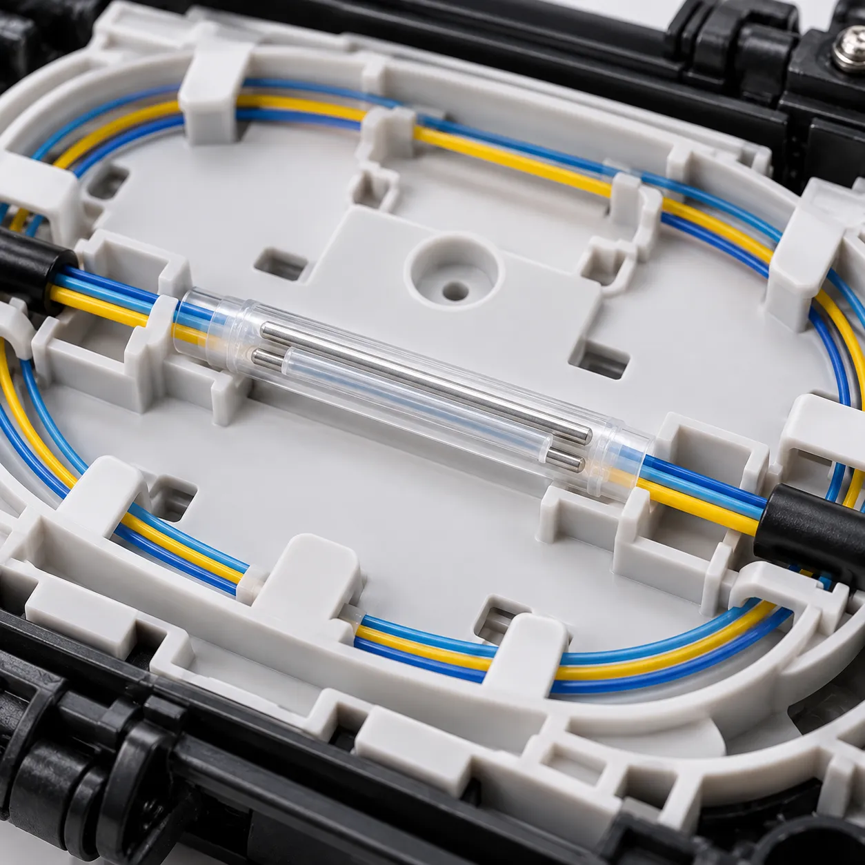 Dual pin fiber optic splice protection sleeve installed in a fiber splice tray protecting a splice in an FTTH fiber optic cable application